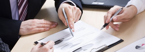 Close-up of business partners hands over papers discussing them
